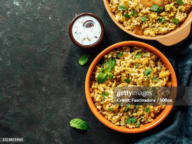 high angle view of food in bowl on table - biryani stock-fotos und bilder