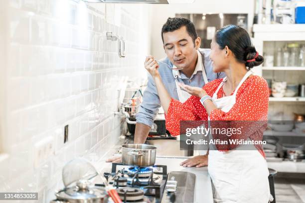 a spouse couple cooking together in the kitchen - malay lover stock pictures, royalty-free photos & images