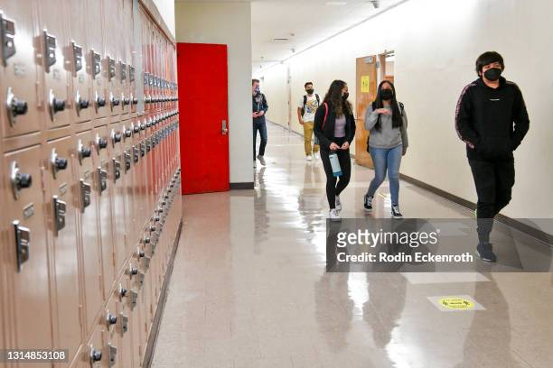 Returning students walk the hallway at Hollywood High School on April 27, 2021 in Los Angeles, California. Los Angeles Unified School District middle...