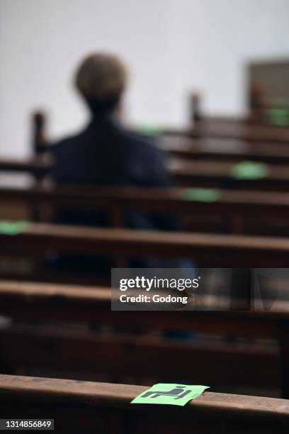 Church during the Coronavirus epidemic. COVID-19 instructions : sanitizing gel, surgical mask and social distancing during catholic mass celebration....