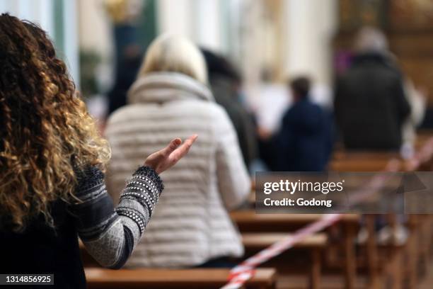 Church during the Coronavirus epidemic. COVID-19 instructions : sanitizing gel, surgical mask and social distancing during catholic mass celebration....