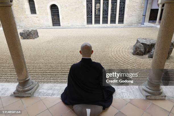 Zen buddhist monk practising zazen in Orval trappist abbey's zen garden, Belgium.