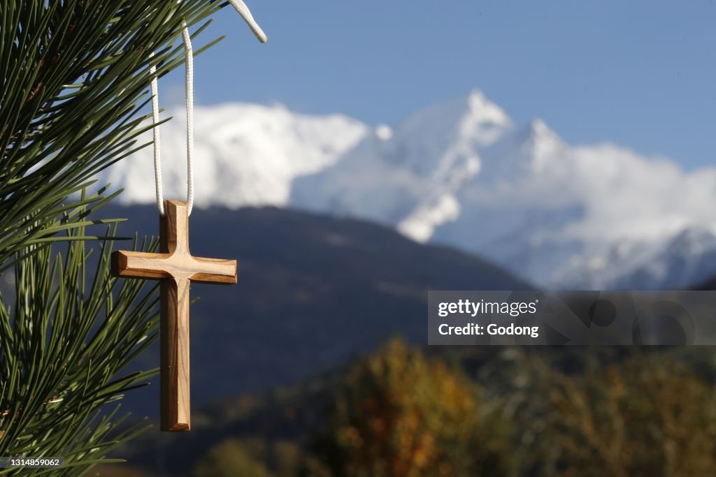 Christian wooden cross on fir tree branches