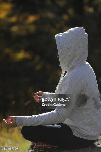 Woman praying and practicing meditating on nature. France.