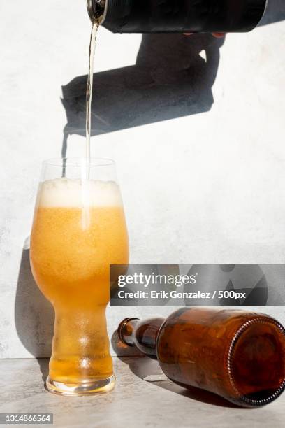 close-up of beer pouring in glass on table - beer close up stock pictures, royalty-free photos & images