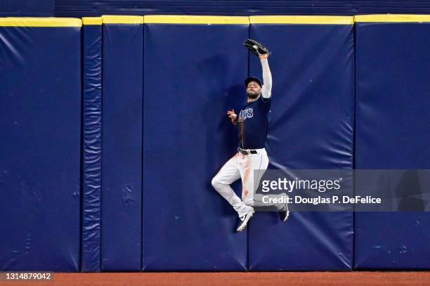 Kevin Kiermaier of the Tampa Bay Rays catches a fly ball on the warning track during the fourth inning against the Oakland Athletics at Tropicana...