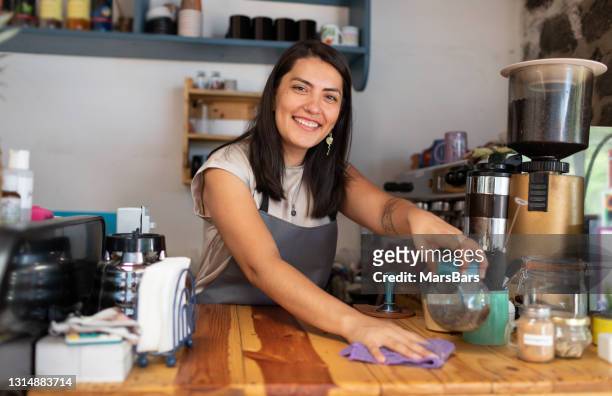 schöne lächelnde barista serviert kaffee und kekse in der cafeteria - mexikanischer abstammung stock-fotos und bilder