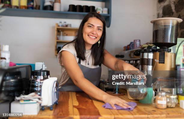 bella barista sonriente sirviendo café y galletas en cafeteria - mujeres mexicanas fotografías e imágenes de stock