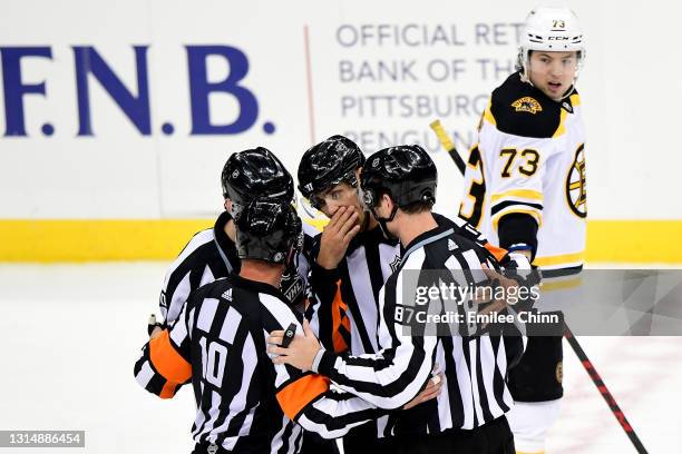 Charlie McAvoy of the Boston Bruins watches as referees and linesmen discuss a play in the third period during a game between the Pittsburgh Penguins...