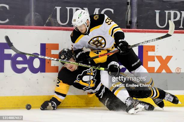 Jeremy Lauzon of the Boston Bruins and Kasperi Kapanen of the Pittsburgh Penguins battle for the puck in the second period during their game at PPG...