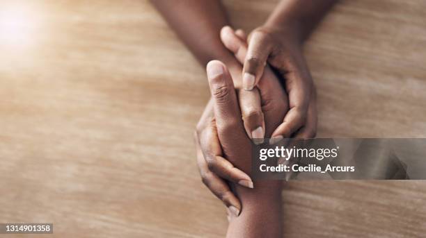 tiro de ângulo alto de duas mulheres irreconhecíveis de mãos dadas - reconciliation - fotografias e filmes do acervo