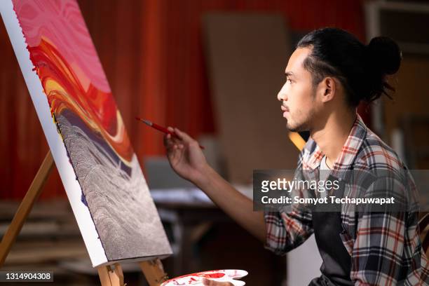 young asian male woman paint drawing acrylic color on canvas at studio - pittore artista foto e immagini stock