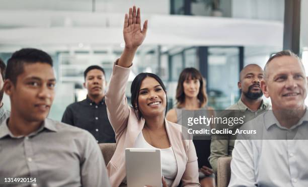 foto de una joven empresaria levantando la mano durante una presentación en una oficina - alzar los brazos fotografías e imágenes de stock