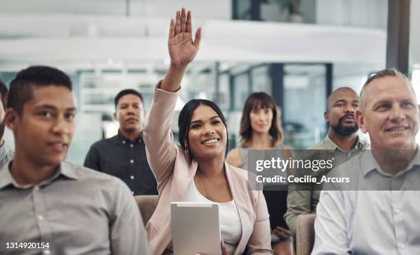 scatto di una giovane imprenditrice che alza la mano durante una presentazione in un ufficio - feedback foto e immagini stock