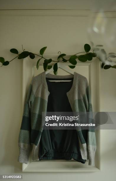 knitted cardigan in green color on a hanger - hanging clothes stock pictures, royalty-free photos & images