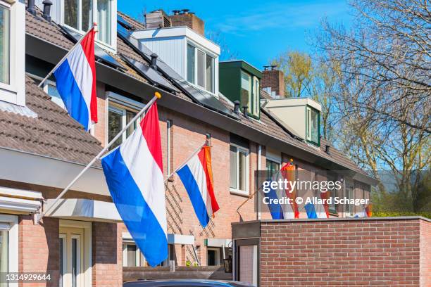 dutch flags hanging outside houses in alkmaar, netherlands to celebrate king's day on april 27, a national holiday in the netherlands and birthday of king willem-alexander - kings day netherlands stock pictures, royalty-free photos & images