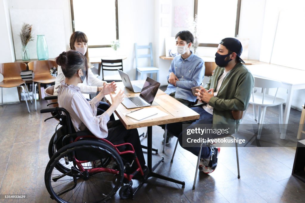 Woman on wheelchair with her collegue at office