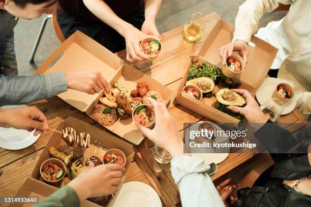 friends having home party with vegan food - packaging of food stockfoto's en -beelden