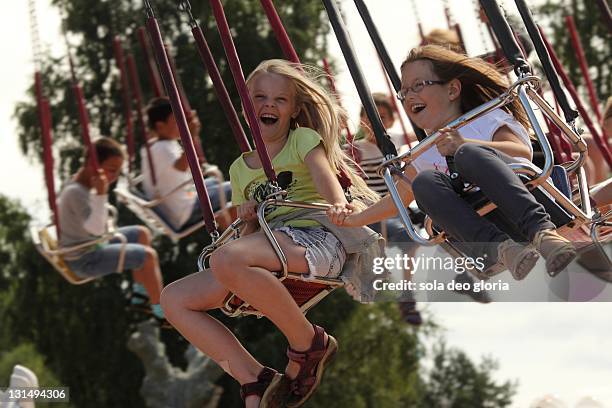 girls riding carousel - skara stock-fotos und bilder