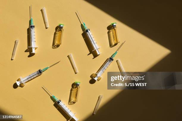 syringe and vaccine against yellow background top view - ácido hialurónico imagens e fotografias de stock
