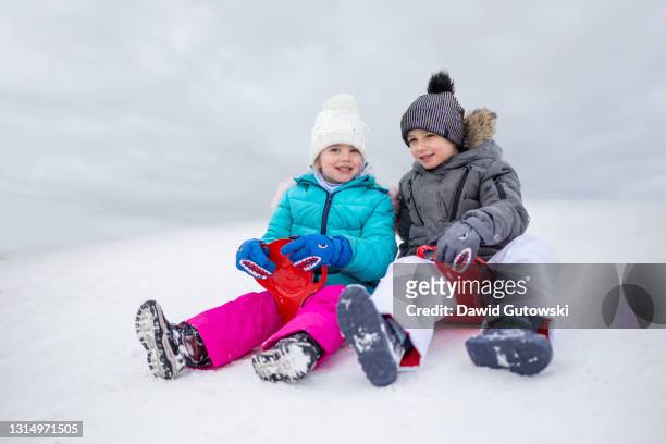 joyful children on the ski slope in winter - 橇 ストックフォトと画像
