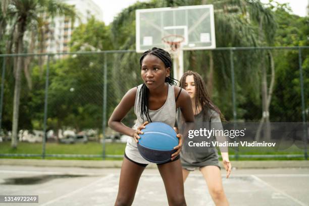 teenager-mädchen spielen basketball in ihrer nachbarschaft in brasilien - dribbling sports stock-fotos und bilder