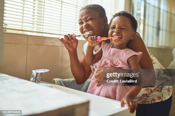 tiro de uma mulher e sua filha escovando os dentes em casa - dentes - fotografias e filmes do acervo