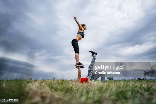 couple doing acroyoga - acroyoga stock pictures, royalty-free photos & images