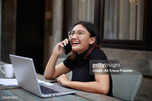 young asian woman, working outdoor, smiling, using their phone - インドネシア人 ストックフォトと画像