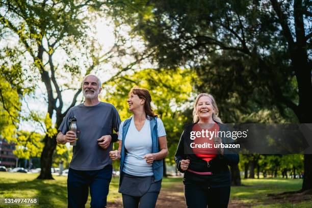 actieve hogere mensen die in park lopen - 3 old men jogging stockfoto's en -beelden