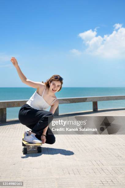 young woman riding skateboard - woman longboard stock pictures, royalty-free photos & images
