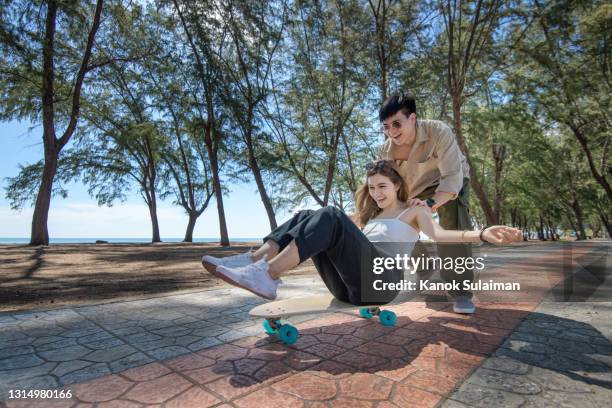 beautiful couple having fun skateboarding - couple skating stock pictures, royalty-free photos & images