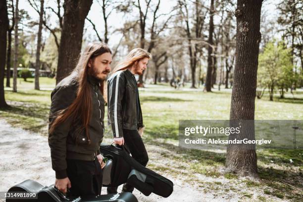 long haired males with guitars making rehearsal in park - guitar pick stock pictures, royalty-free photos & images