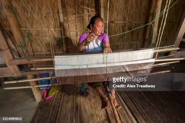 a woman from north east india weaving on a traditional handloom - northeast india stock pictures, royalty-free photos & images