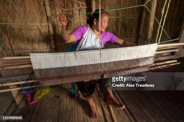 a woman from north east india weaving on a traditional handloom - northeast india stock pictures, royalty-free photos & images