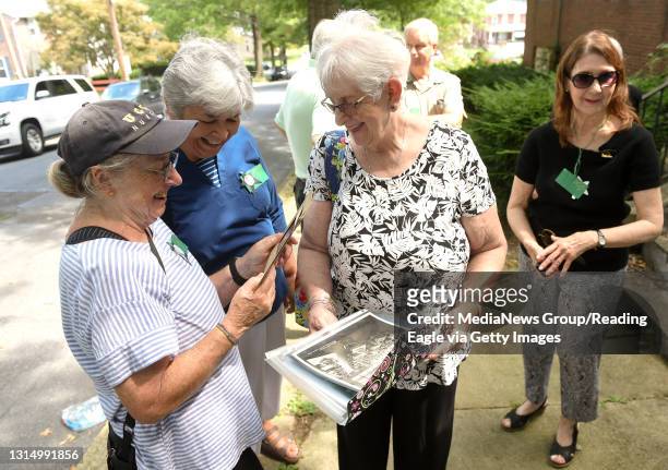 From left are Clare Bowen, of Reading, Chris Seghetti, of Reading and Mary Jo Berthinet looking at old photos from their time at St. John Baptist De...