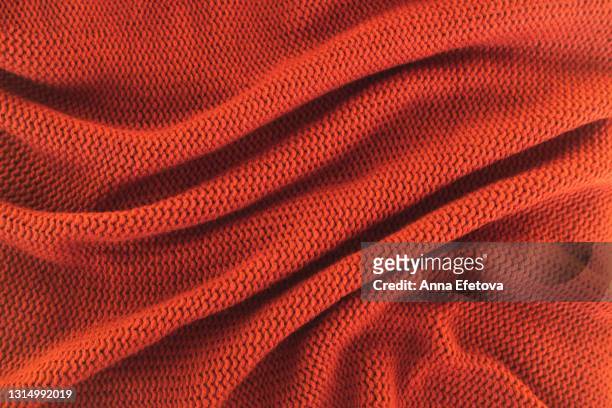 texture of knitted red sweater folded in a swirling pattern. flat lay style, close-up. - beddengoed stockfoto's en -beelden