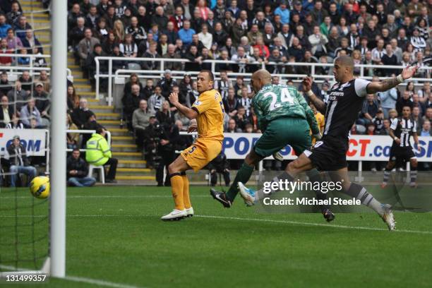 John Heitinga of Everton deflects the ball past goalkeeper Tim Howard to score an own goal during the Barclays Premier League match between Newcastle...