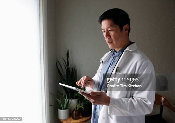 close up of a medical professional using a digital tablet - chinese hero fotografías e imágenes de stock