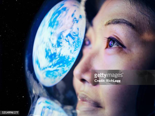 woman in space with earth reflection - roupa de astronauta imagens e fotografias de stock