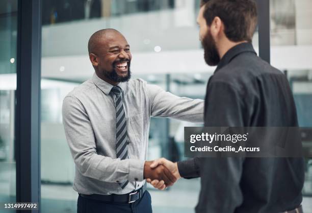 shot of a mature businessman shaking hands with a colleague in a modern office - passion job stock pictures, royalty-free photos & images