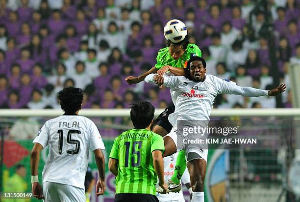 South Korea's Jeonbuk Hyundai Motors defender Kim Sang-Sik jumps for the ball with Qatar's Al Sadd Keita Abdul Kader during the AFC Champions League...