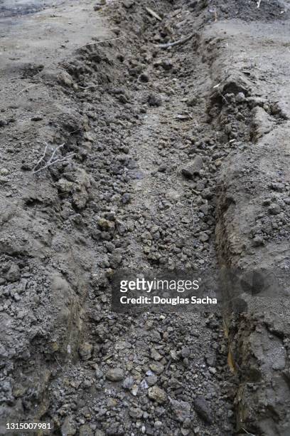 trench in a muddy construction site - digging hole stock pictures, royalty-free photos & images