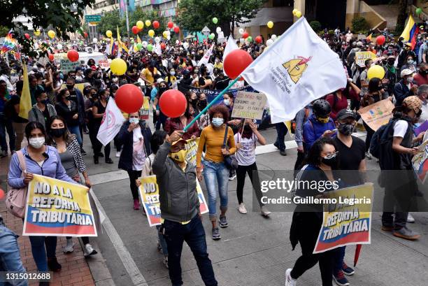 Protesters wearing face masks march during the national strike against the tax reform proposed by Duque's administration on April 28, 2021 in Bogota,...