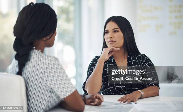 shot of a young businesswoman having a discussion with a colleague in a modern office - bois table stock pictures, royalty-free photos & images