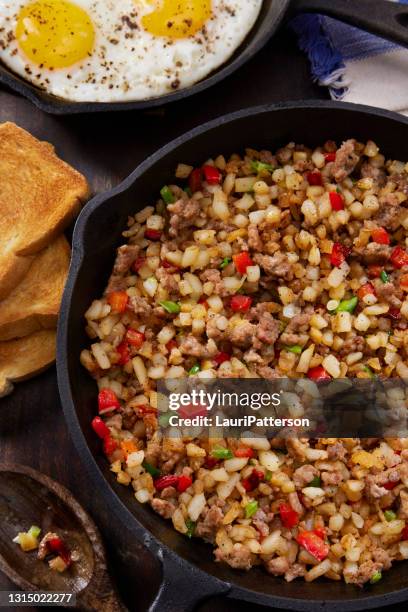 sausage skillet scramble with hash browns and fried eggs - wooden spoon stock pictures, royalty-free photos & images