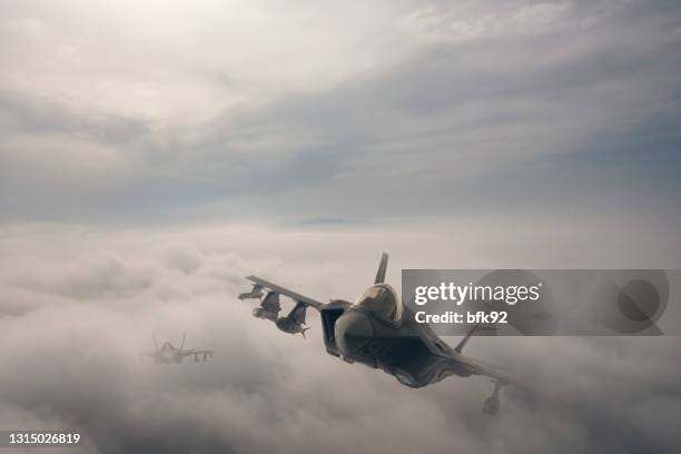 aviones a reacción sobrevolando las nubes. - avión de caza fotografías e imágenes de stock