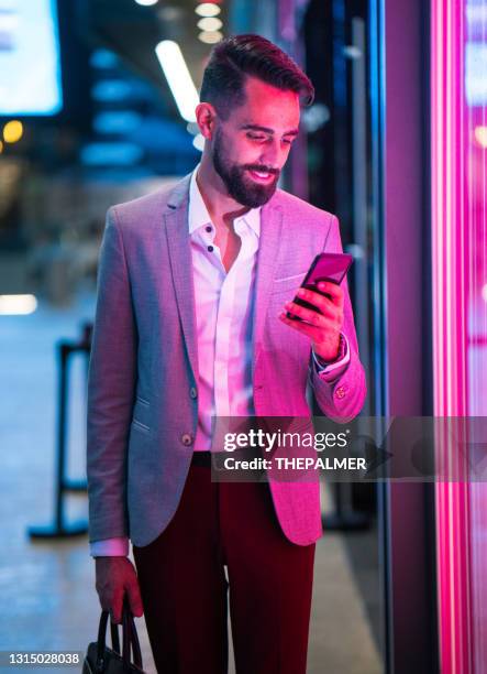 young latin entrepreneur wearing a suit illuminated by pink light - miami business stock pictures, royalty-free photos & images