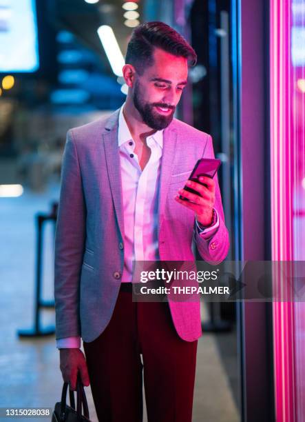 young latin entrepreneur wearing a suit illuminated by pink light - miami business imagens e fotografias de stock