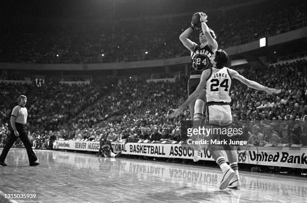 Golden State Warriors forward Rick Barry shoots a jumper from the corner while being defended by Denver Nuggets forward Bobby Jones during an NBA...